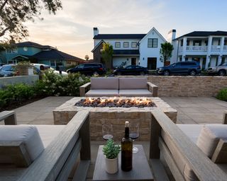 patio with a fire pit and low chairs looking out onto a wide street