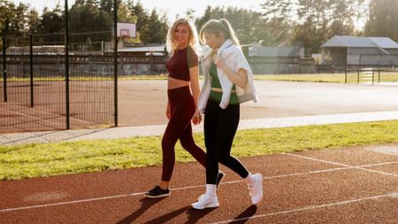 two women walking on a track