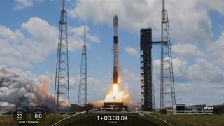 a rocket launches against blue cloudy skies