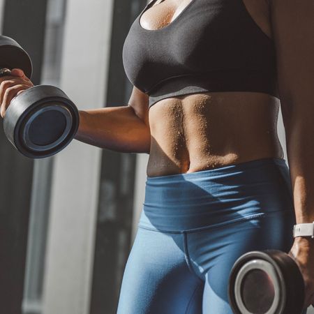 A woman doing EMOM workouts in the gym with weights