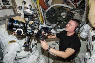 NASA astronaut Kjell Lindgren prepares the IMAX® camera for an upcoming shoot onboard the International Space Station.