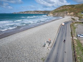 Drone shot of a cyclist riding next to the Welsh Pembrokeshire coast