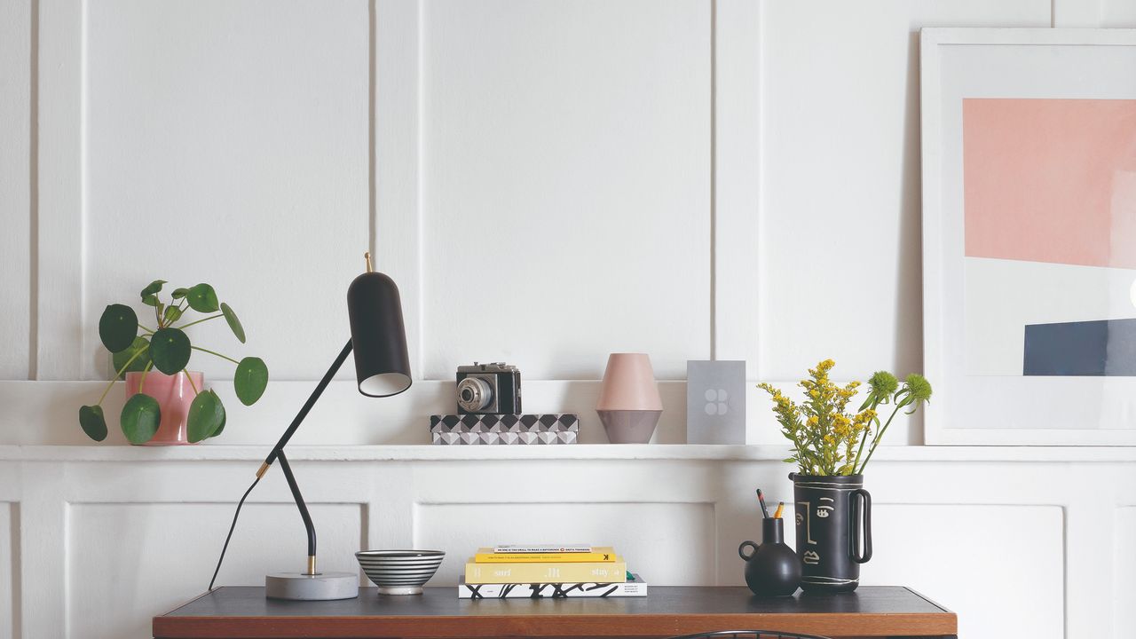 A home office with wall panelling, a desk and an abstract art print