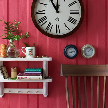 hallway with red wall and wall clock