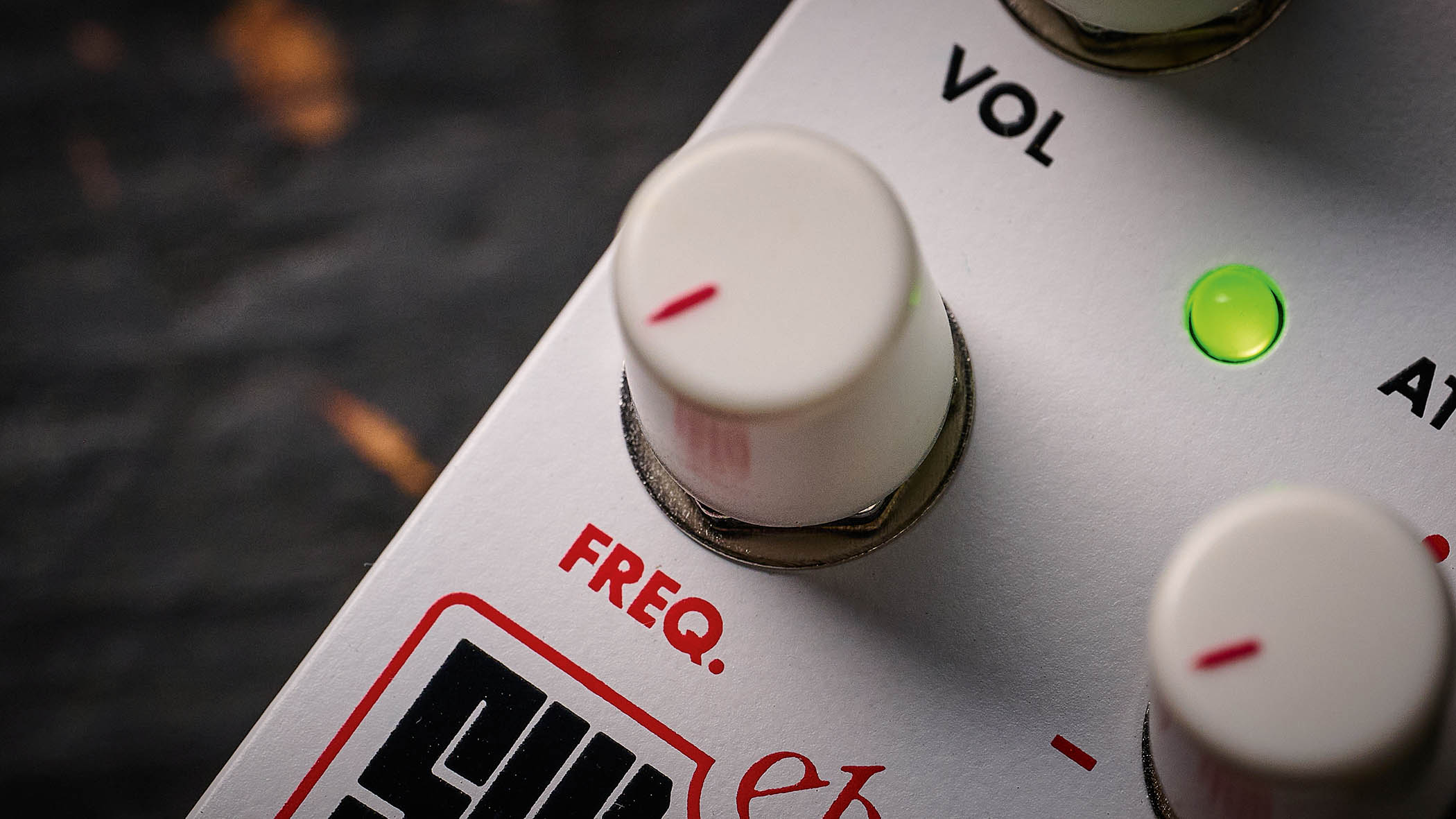 Electro-Harmonix Pico Swello: the compact mini-pedal is finished in white and has black and white text, four knobs, and is photographed against a distressed wood floor.