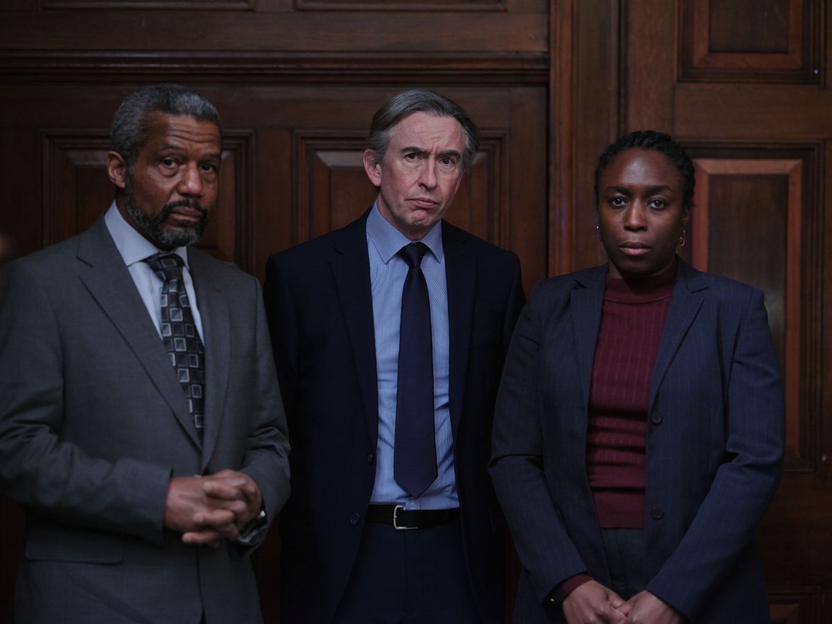 Stephen: Hugh Quarshie as Neville Lawrence, Steve Coogan as DCI Clive Driscoll and Sharlene Whyte as Doreen Lawrence, all in suits and standing in a dark panelled room