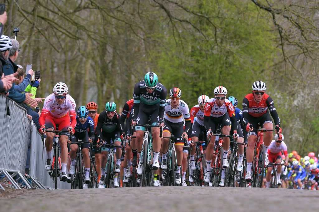 The peloton crests the Kemmelberg