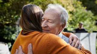 Woman hugging older dad, representation of caregiver burnout