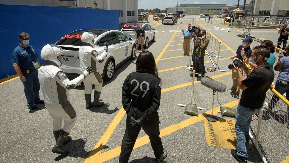 NASA astronauts Bob Behnken and Doug Hurley walk out of NASA's Astronaut Crew Quarters and take a Tesla Model X to Launch Pad 39A during a dry-run test of their SpaceX Crew Dragon Demo-2 flight on May 23, 2020 at the Kennedy Space Center in Florida.
