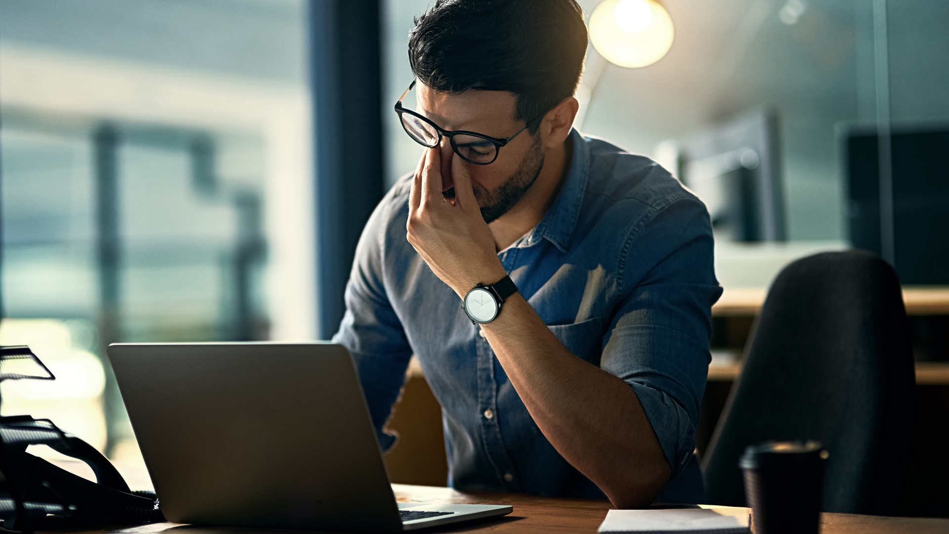 el hombre que parecía cansado se sentó a trabajar en su escritorio