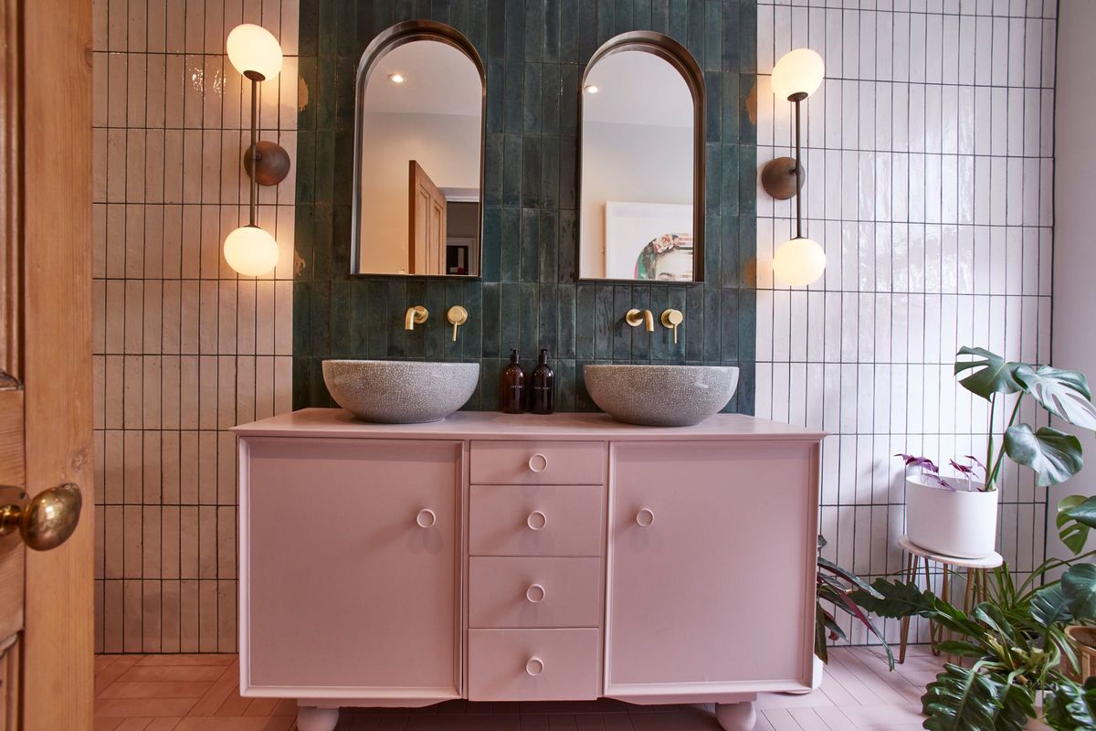 The bottom floor bedroom has an en suite bathroom which has two sinks, which are grey marble with two mirrors above