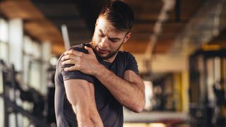 A man holding his shoulder in pain