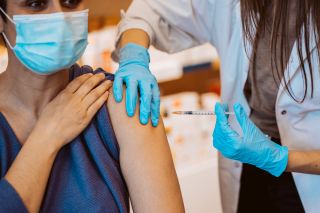 Young woman getting the flu vaccine as she finds out where to get the flu vaccine in the local area