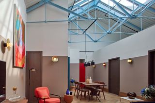 Interior view of Native Manchester featuring a dining table, wooden floors, art on the wall and blue metal framework above