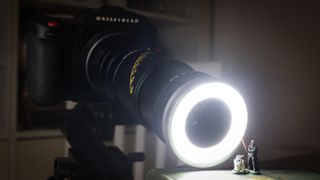 Mitakon 55mm f/2.8 1-5x Macro lens on a Hasselblad camera with light, in front of miniature Darth Vader and R2-D2 figures
