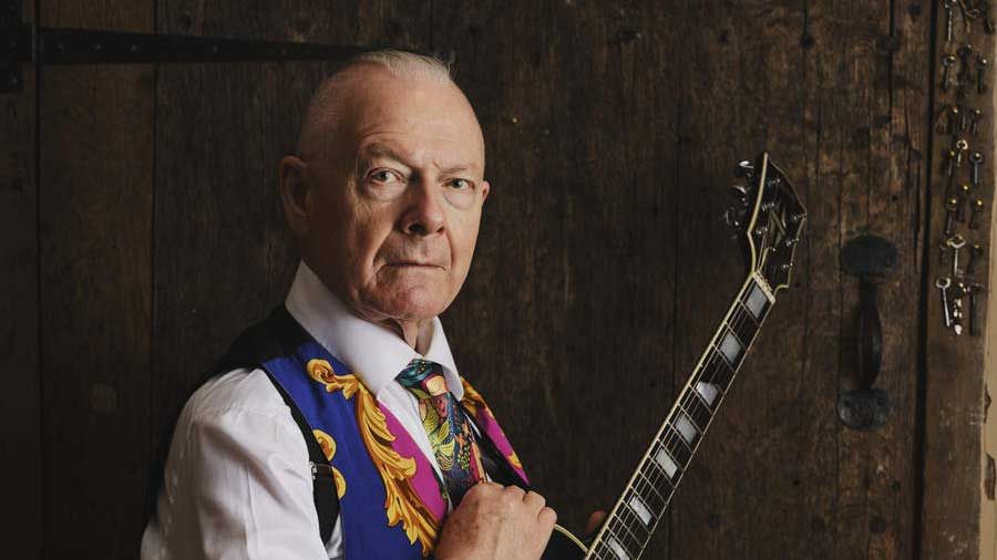 Robert Fripp holding a guitar