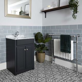 bathroom with towel warmer radiator and grey metro tiles with dark grey vanity unit