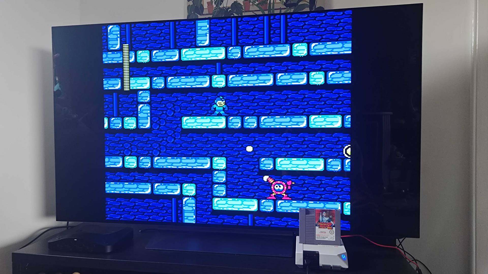 Hyperkin Retron HD console connected to LG OLED TV with Mega Man 2 NES cartridge inserted and gameplay on screen.