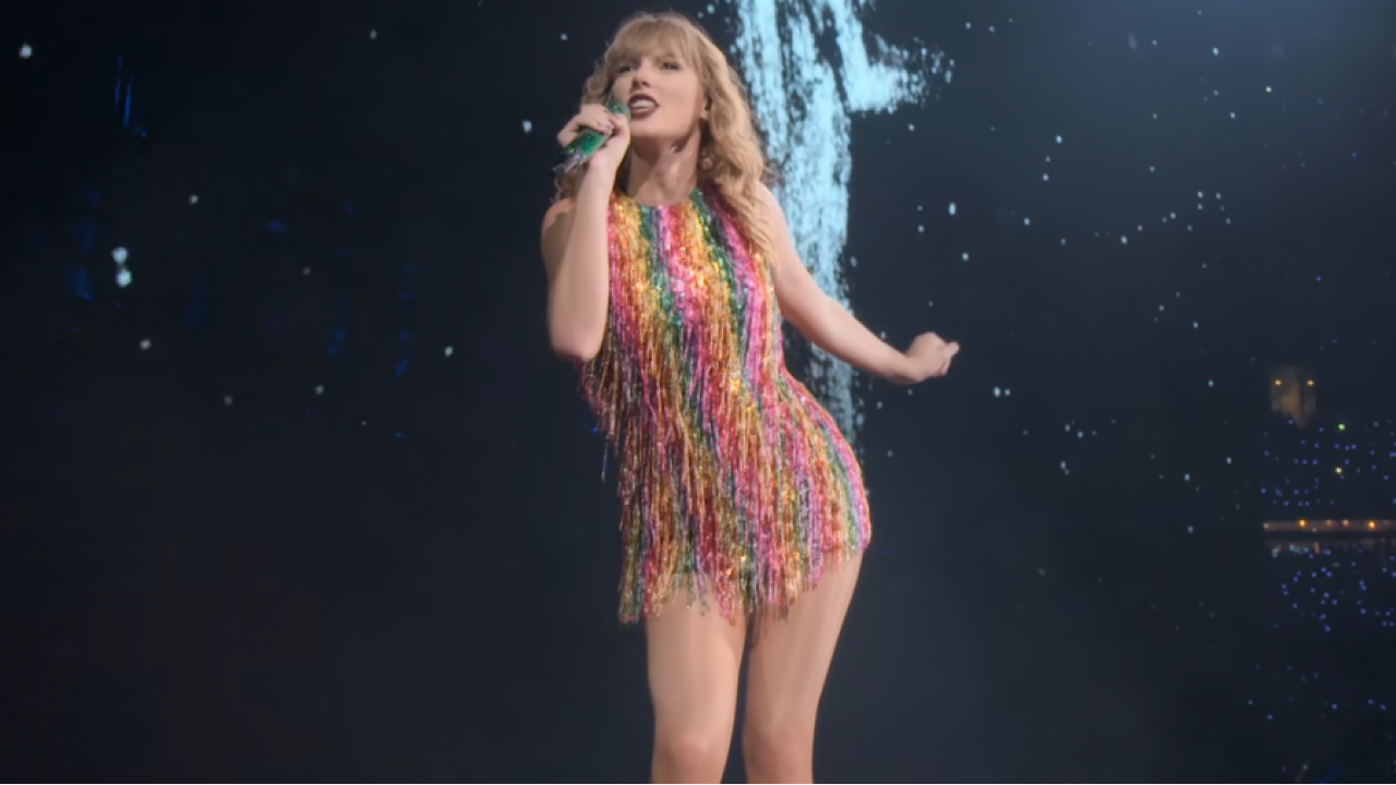Taylor Swift con un vestido de arcoíris cantando durante el Reputation Stadium Tour.