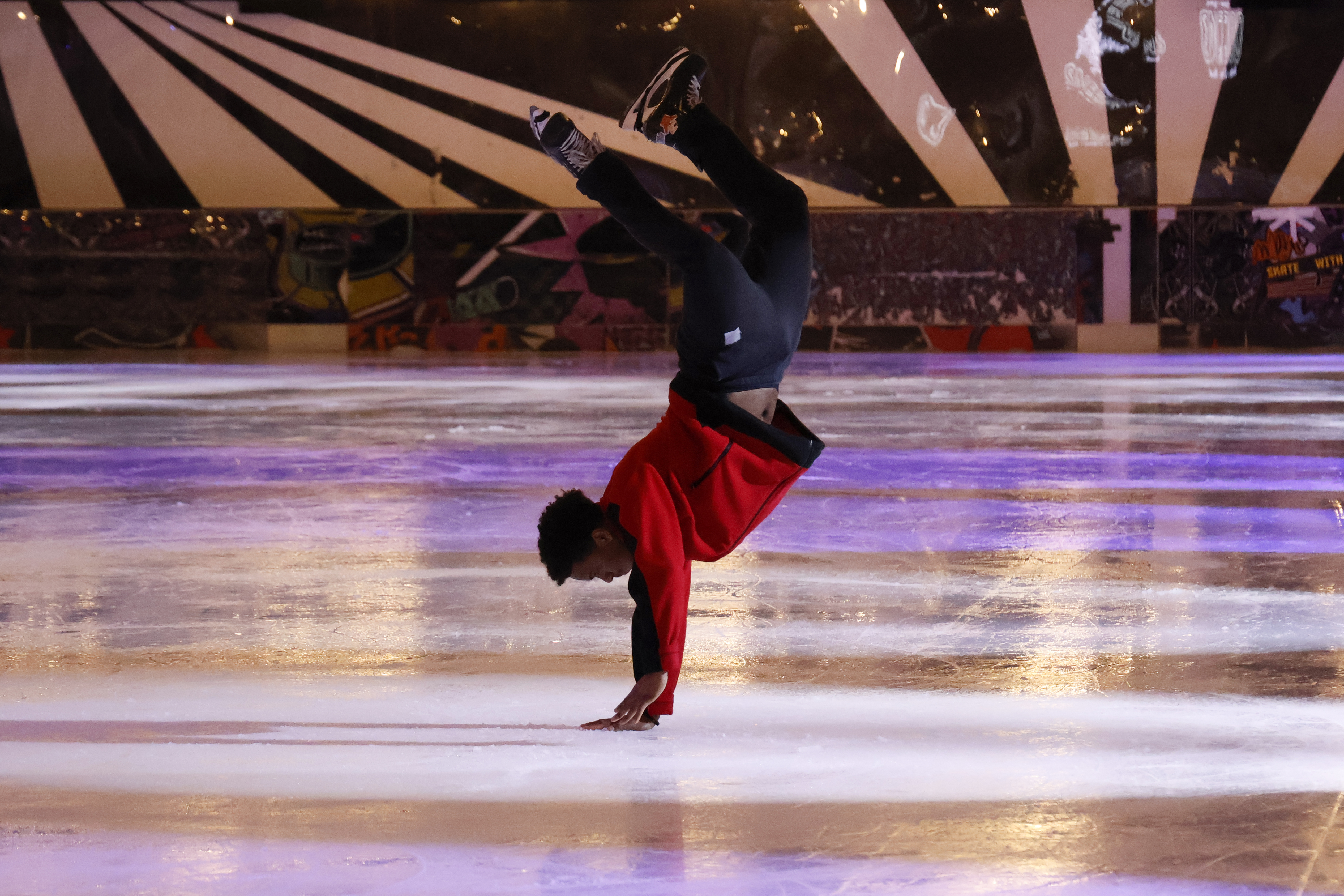 An ice skater performing at an ice rink