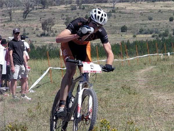 Cal Britten makes the most of the feed zone in the hot conditions. There's not much shade at Stromlo.