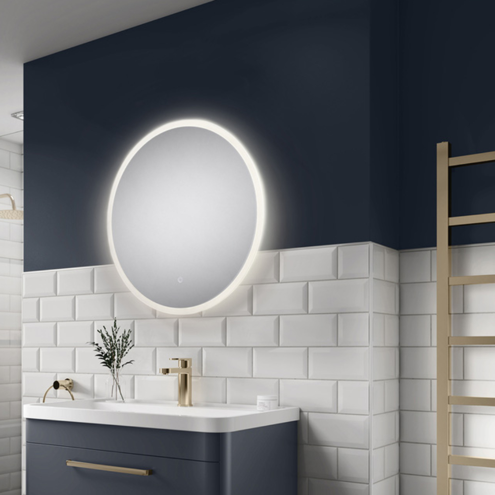 round bathroom mirror with light above navy vanity unit with white sink
