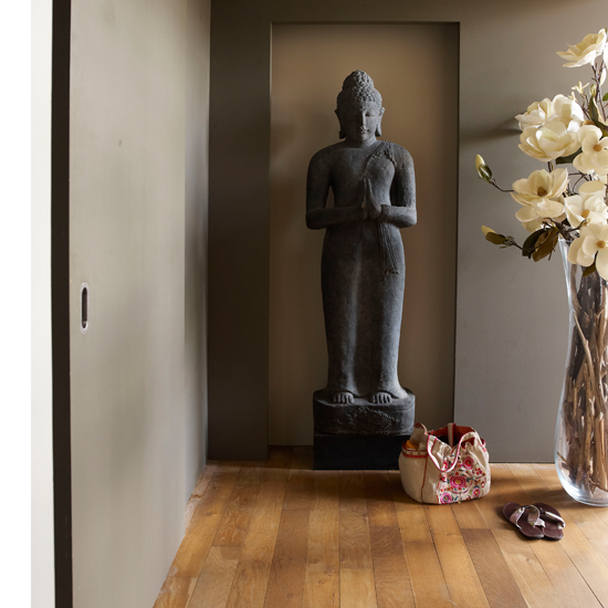 room with wooden flooring and lord buddha statue