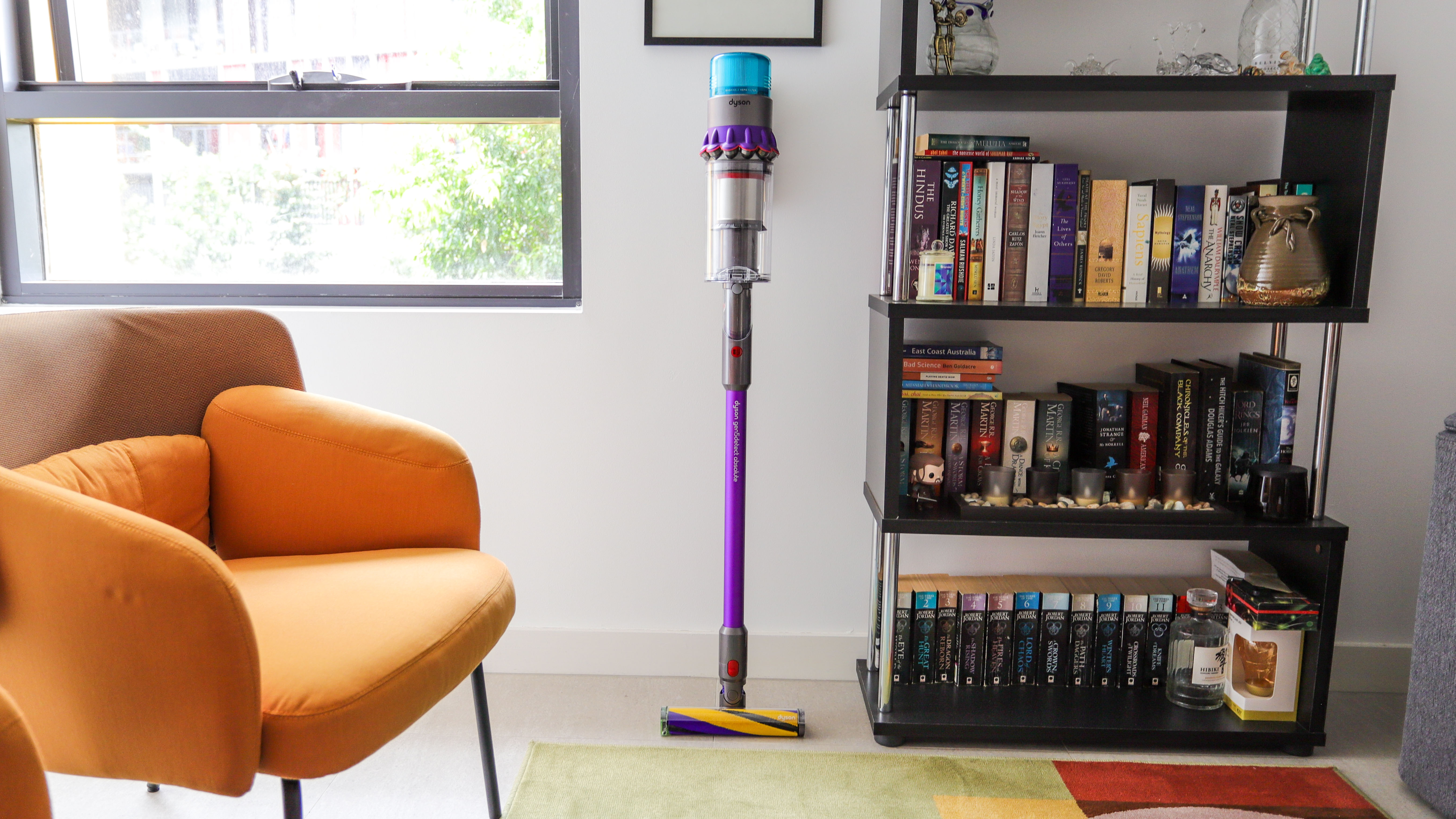 Dyson Gen5 Detect standing beside a bookshelf