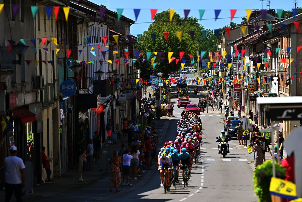LAPLAINETONIQUE FRANCE JULY 31 A general view of the peloton passing through a village while fans cheers during the 35th Tour de lAin 2023 Stage 1 a 154km stage from Loyettes to La Plaine Tonique on July 31 2023 in La Plaine Tonique France Photo by Luc ClaessenGetty Images