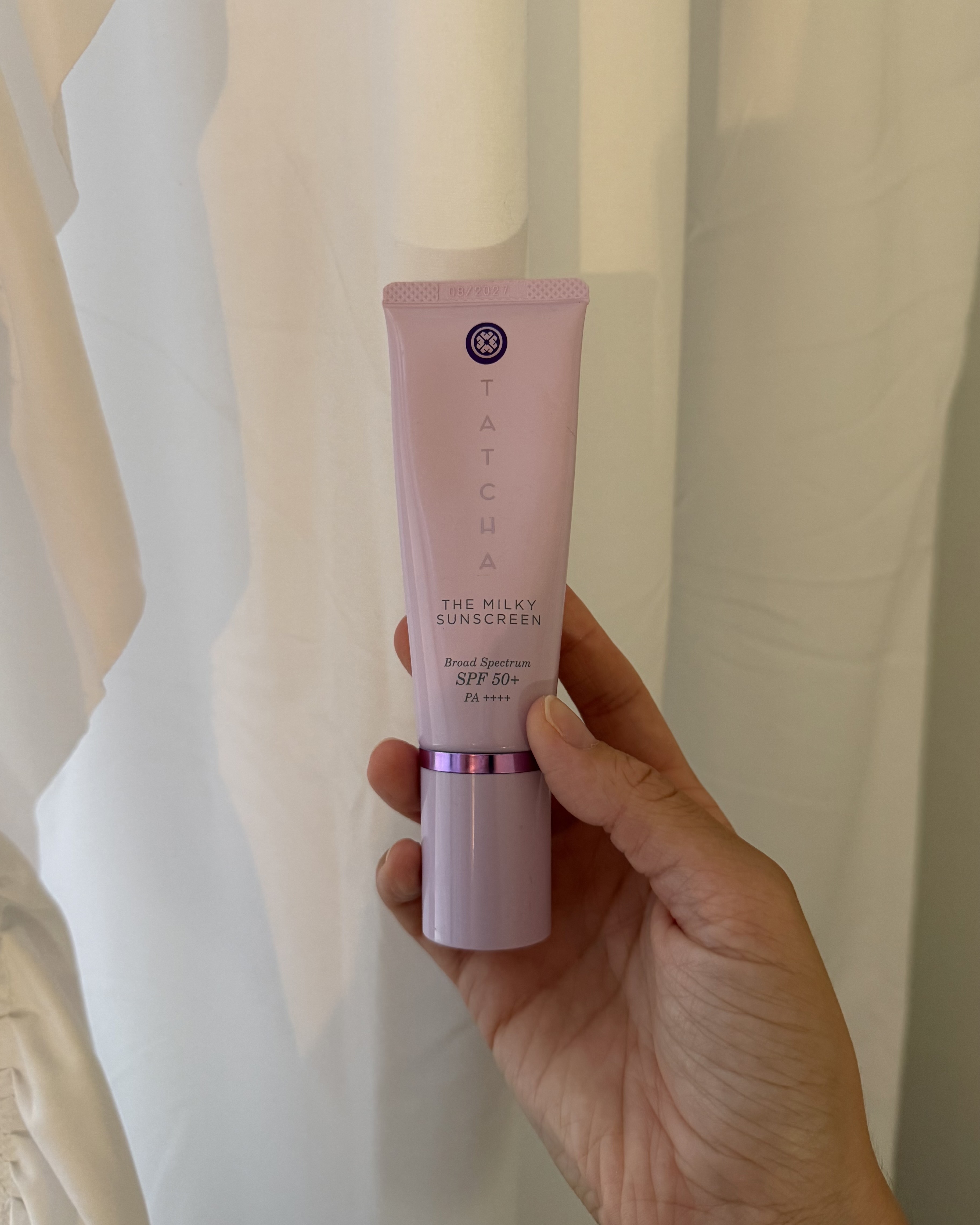 Alyssa Brascia holding a bottle of Tatcha sunscreen.