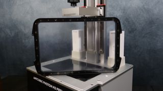 An Anycubic Photon M3 Premium printer in front of a grey textured background