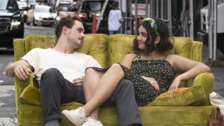 Dacre Montgomery and Geraldine Viswanathan on a couch in The Broken Hearts Gallery poster