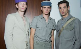 Male models wearing the Bottega Veneta Spring / Summer 2016 collection. The two on the left are wearing colourful beanies and the model on the right has a backpack