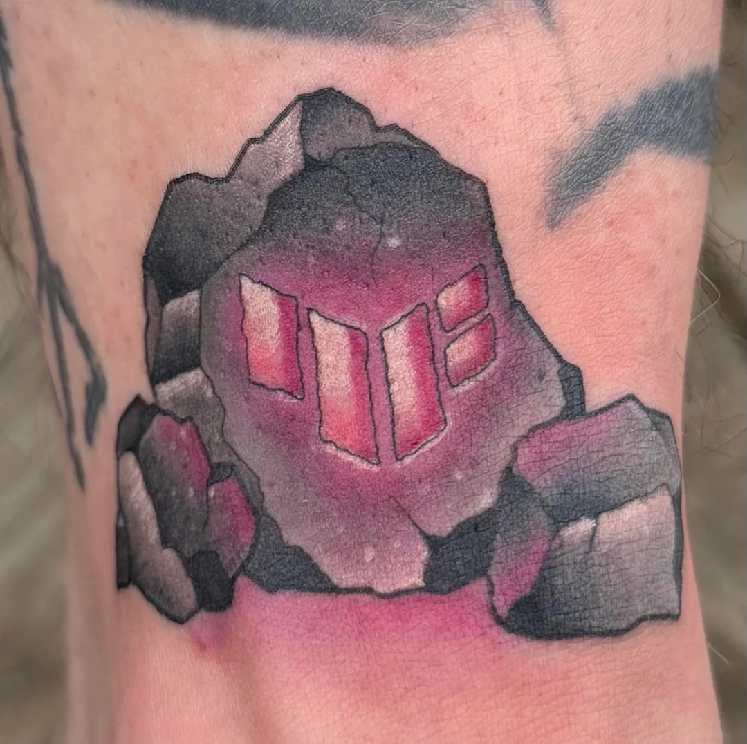A tattoo of the Asus Tuf logo on a rock.