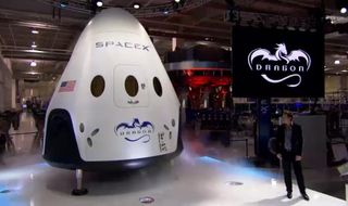 SpaceX CEO and Chief Designer Elon Musk (right) unveils the Dragon V2 manned spacecraft on May 29, 2014 during an event at the company's Hawthorne, California rocket factory.