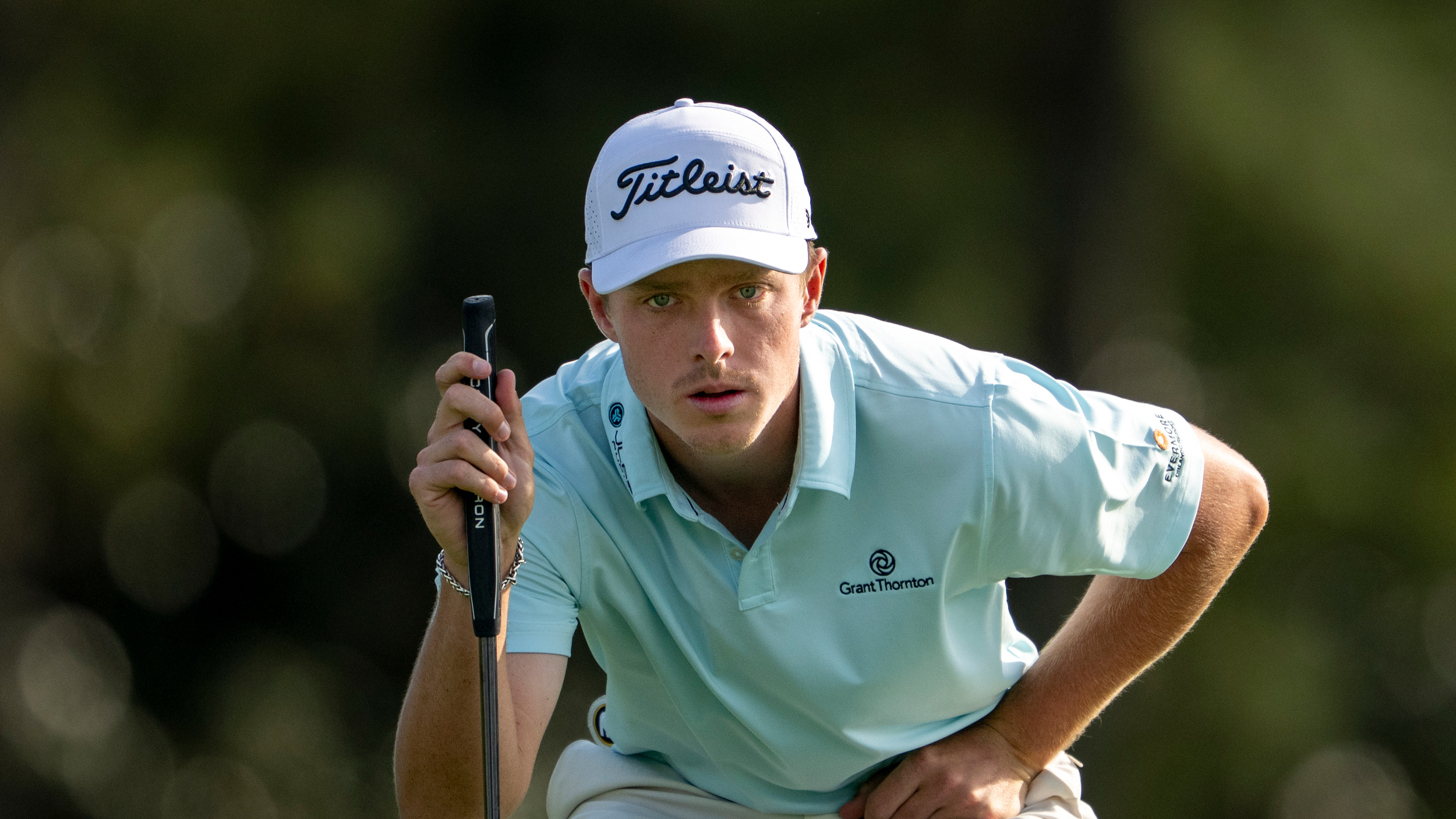 Justin Hastings crouches down behind a putt during The Masters in 2025