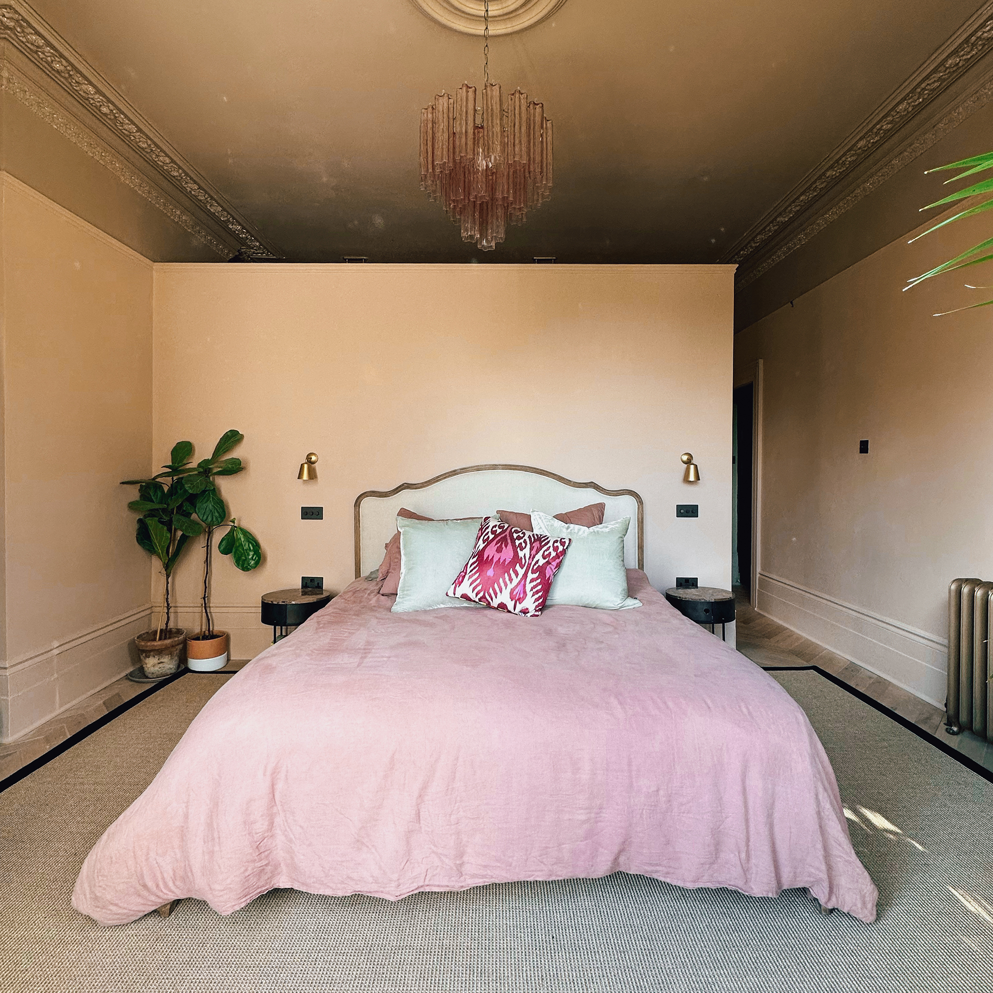 large bedroom with pink walls and bedspread