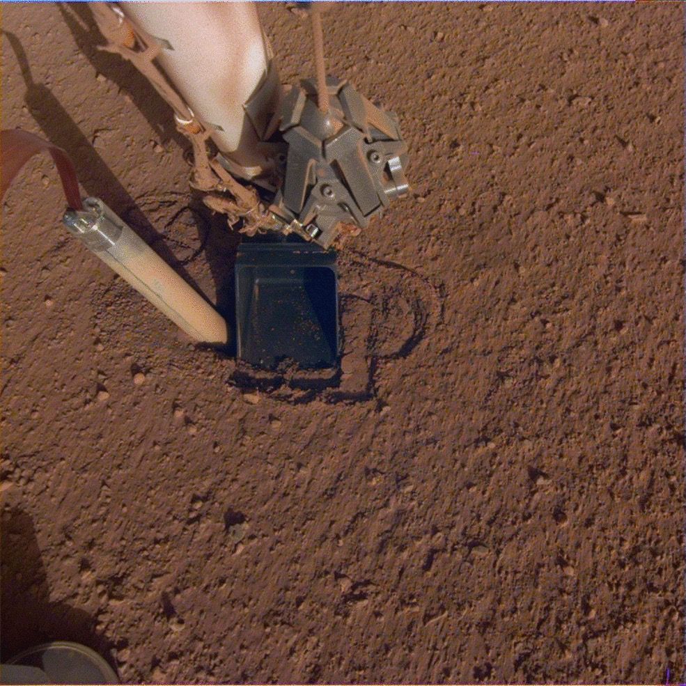 In this image from Oct. 26, 2019, the InSight Mars lander&#039;s heat probe, or &quot;mole,&quot; is seen after backing about halfway out of the hole it had burrowed.