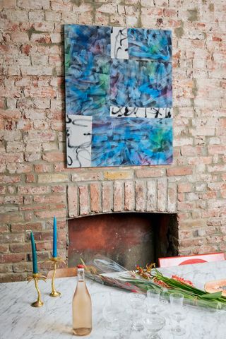 canopy-collections-marble-table-brick-wall-fireplace-with-artwork