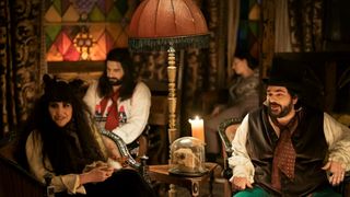 A still from what we do in the shadows season 2 in which Lazlo, Nadia and Nandor sit in their front room.