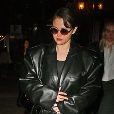 Selena Gomez wears a black leather trench coat in new york city with sunglasses