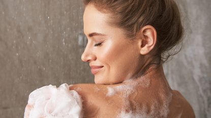 woman showering with body wash for acne