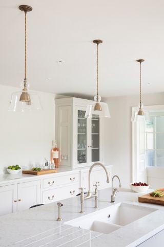 white kitchen with island and pendant lights