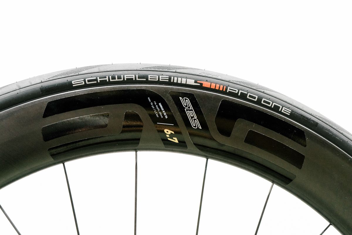 An aero road wheel stands against a white wall