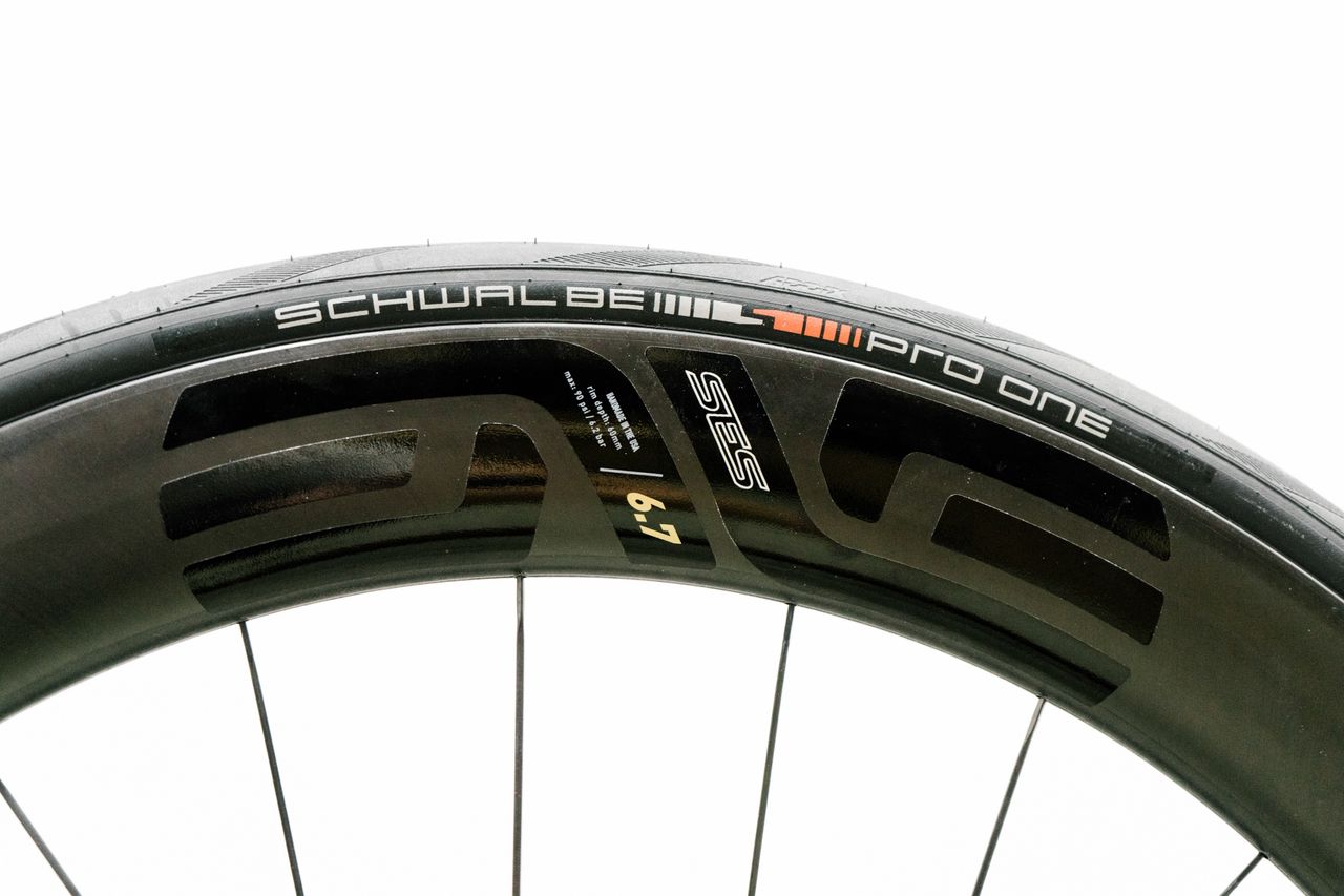An aero road wheel stands against a white wall
