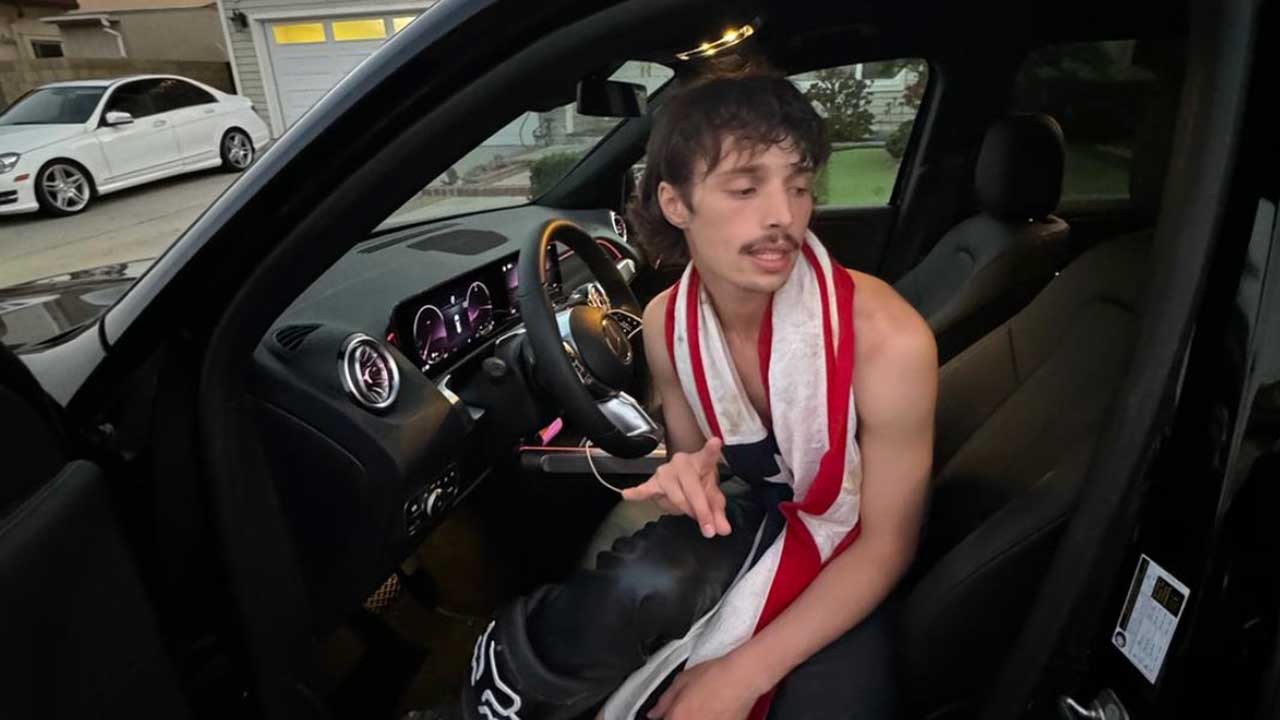 Noah Weiland stepping out of a car wrapped in an American flag