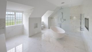 White bathroom with a bathrub, marble floors, and an open plan shower.