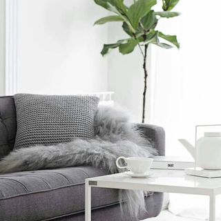 Gray knitted cushion on a couch