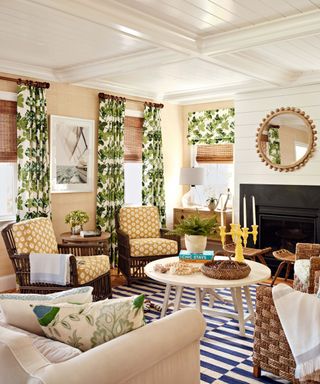 Boldly decorated living rom with green and white curtains, striped blue and white rug and yellow patterned chairs