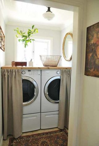 A laundry room with cafe curtain covering white goods